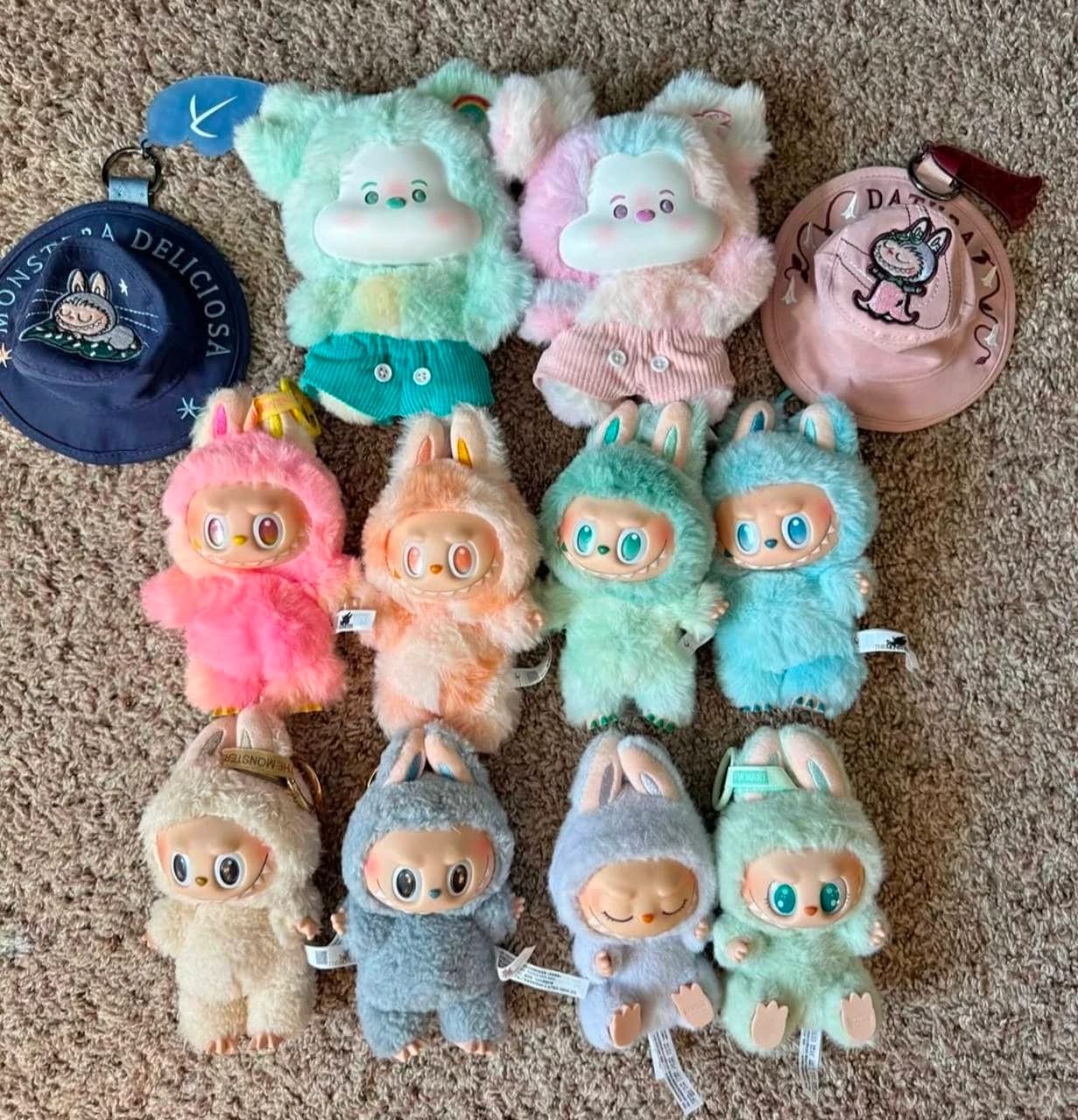 Labubu plush dolls, keychains and miniature hats arranged on carpet